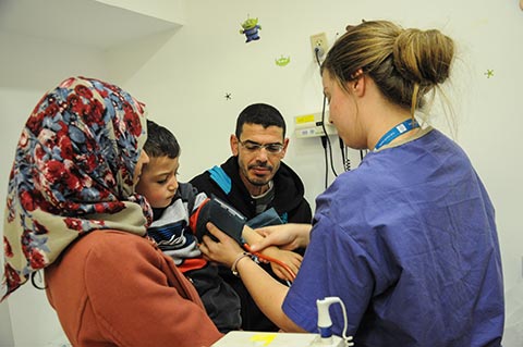 Nurse takes little boy’s blood pressure-Arab Mom and Dad look on